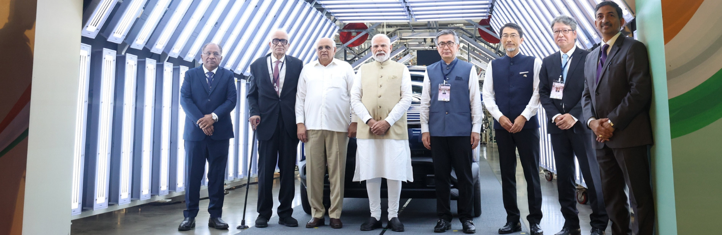 PM in a group photograph at the launch of green mobility initiatives at Hansalpur, in Gujarat